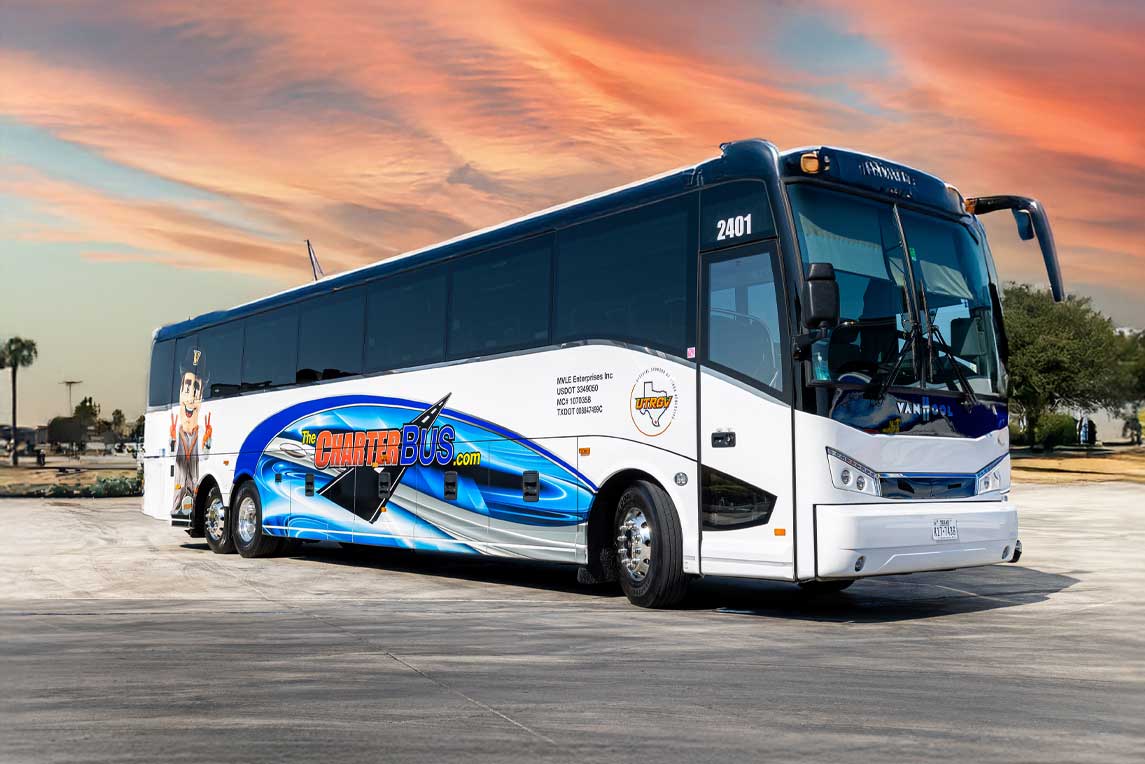 A white bus adorned with a blue and white pattern, stationary in an urban environment.